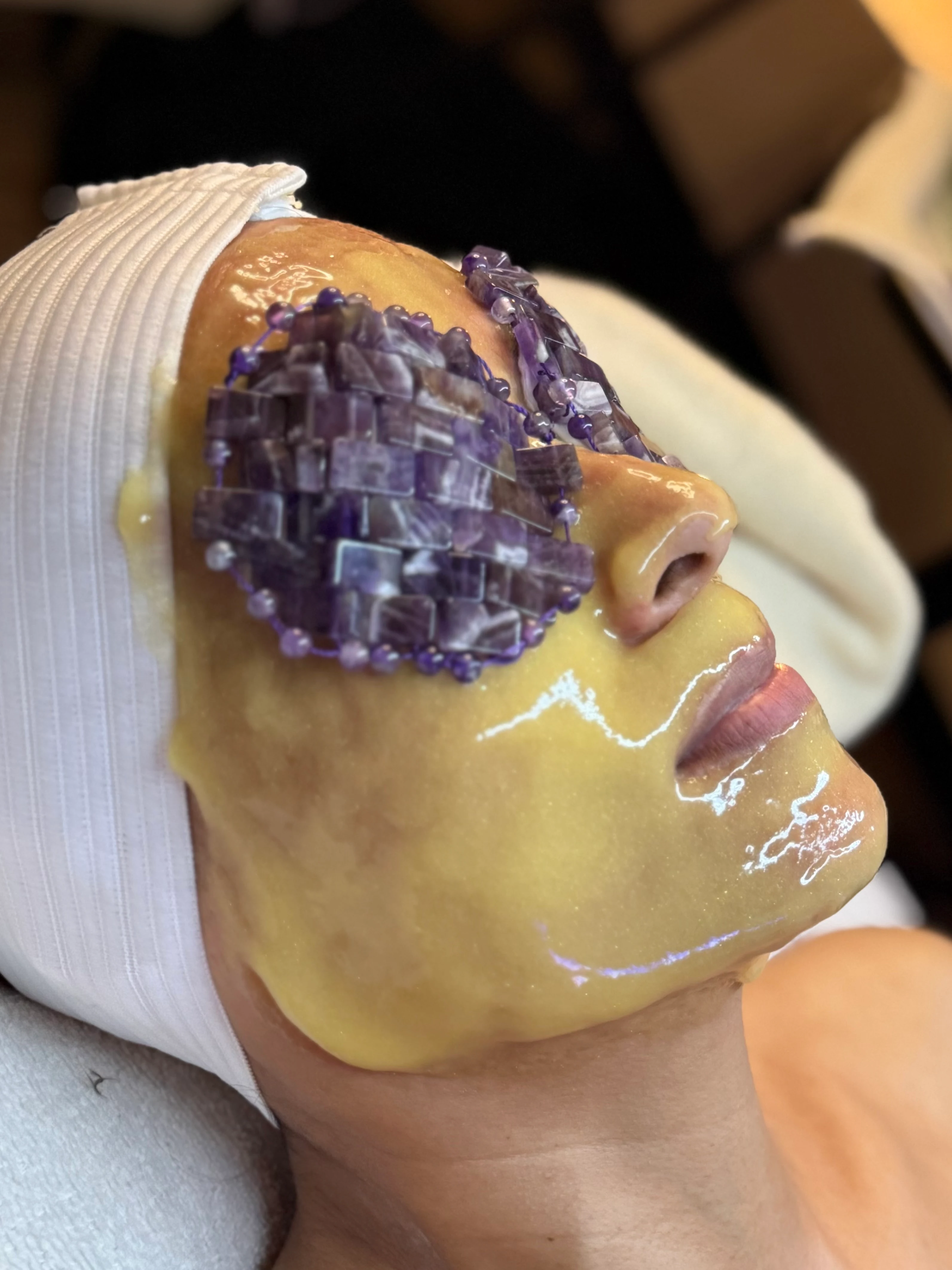 Enzyme mask in progress, amethyst tools on warm skin